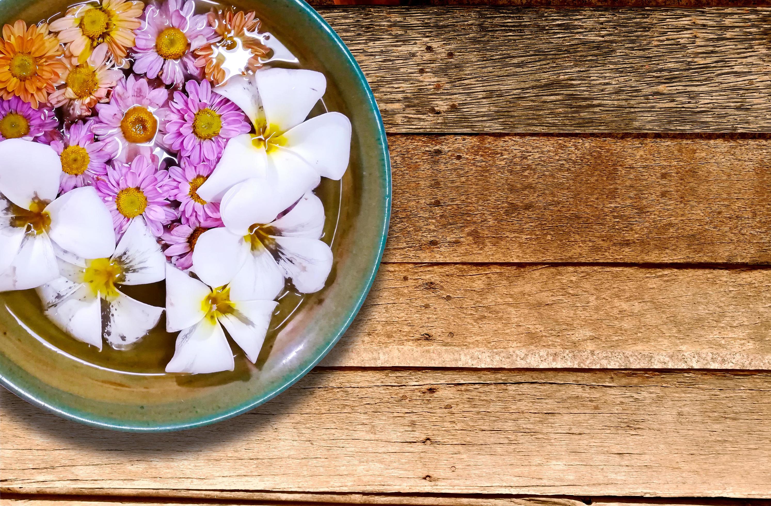 Closeup and crop colorful flowers floating in a porcelain bowl. Stock Free