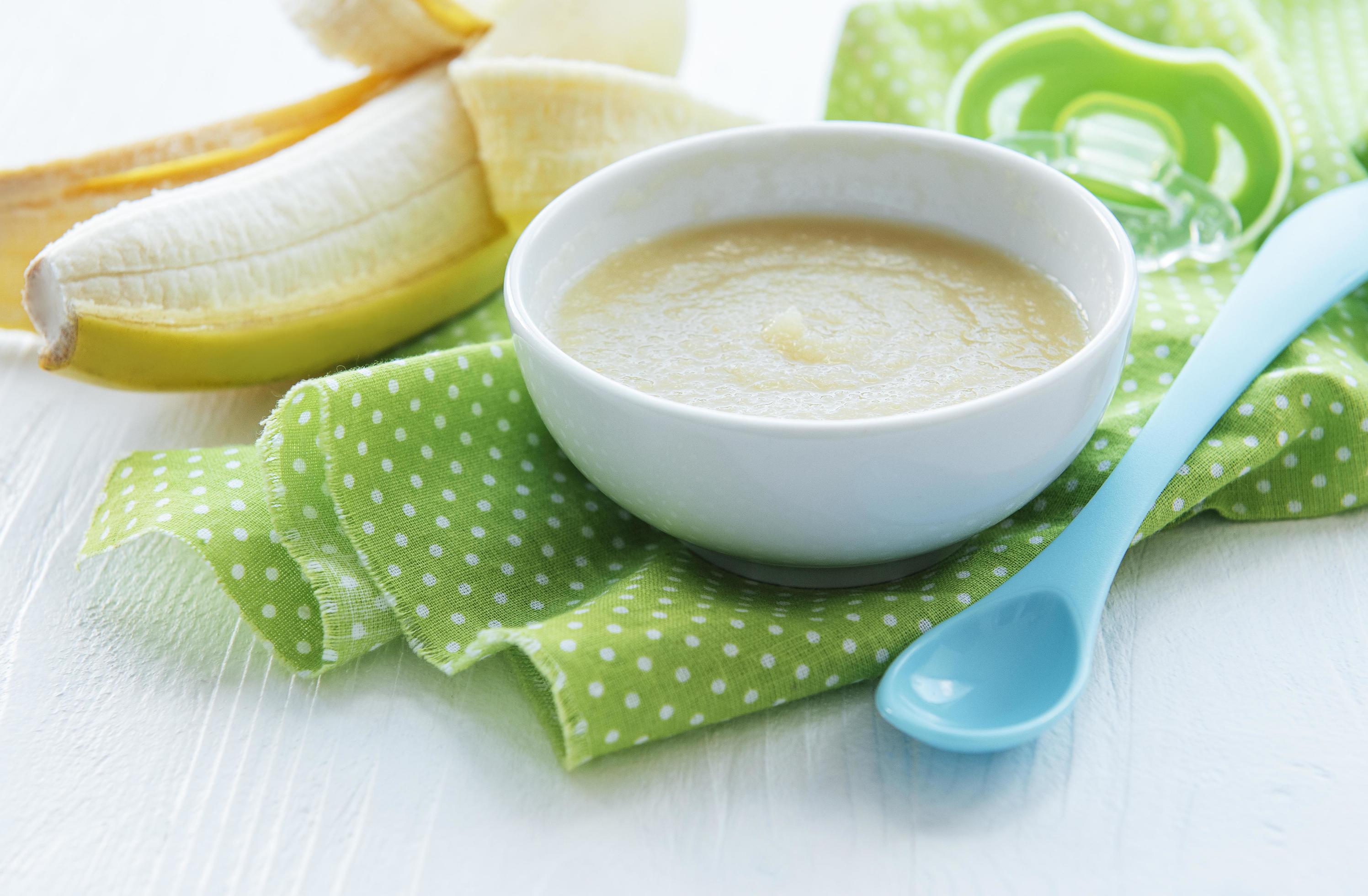 Bowl with fruit baby food and banana Stock Free