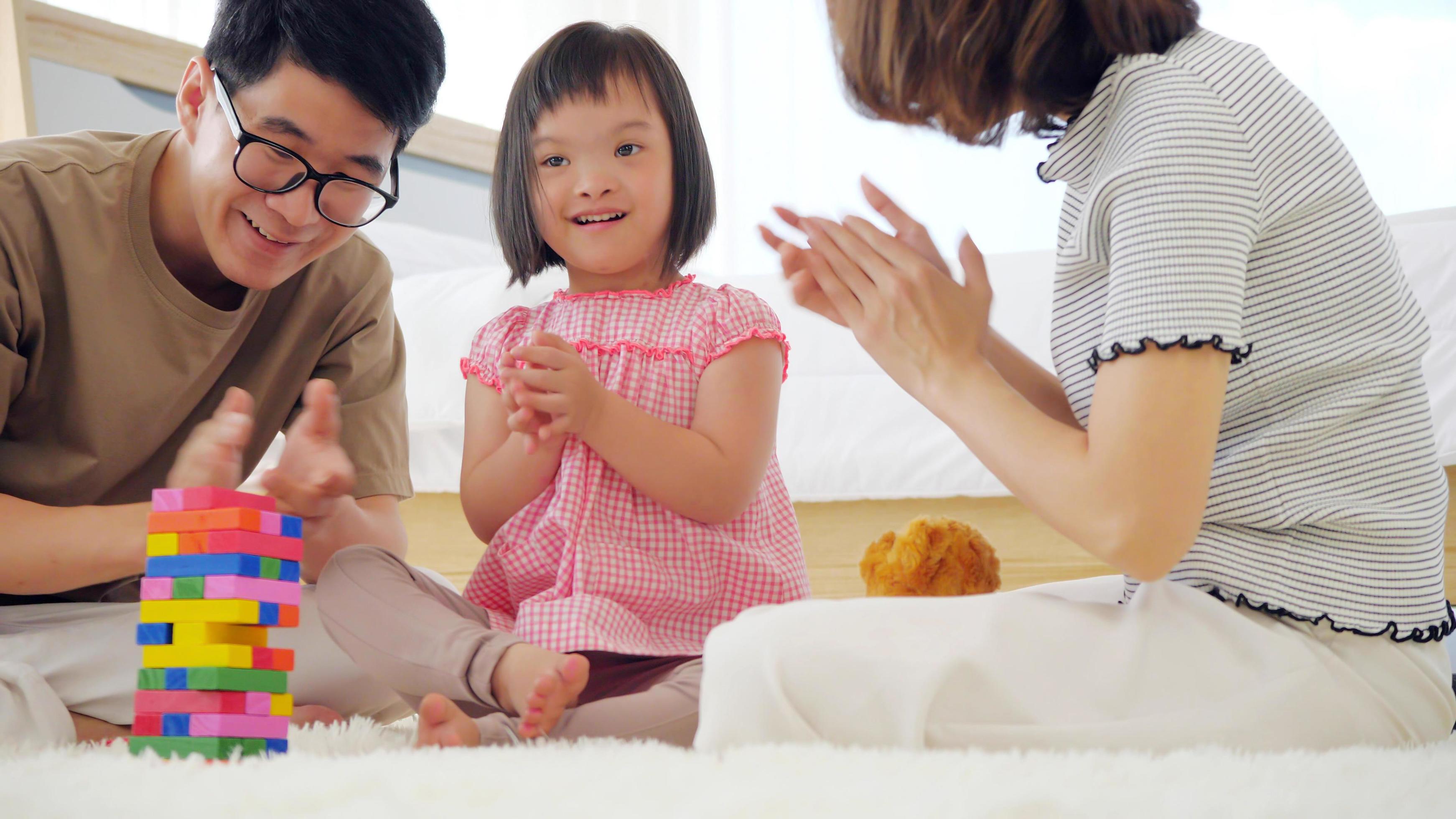 Happy family with mother, father and disabled daughter spending time together at home. Stock Free