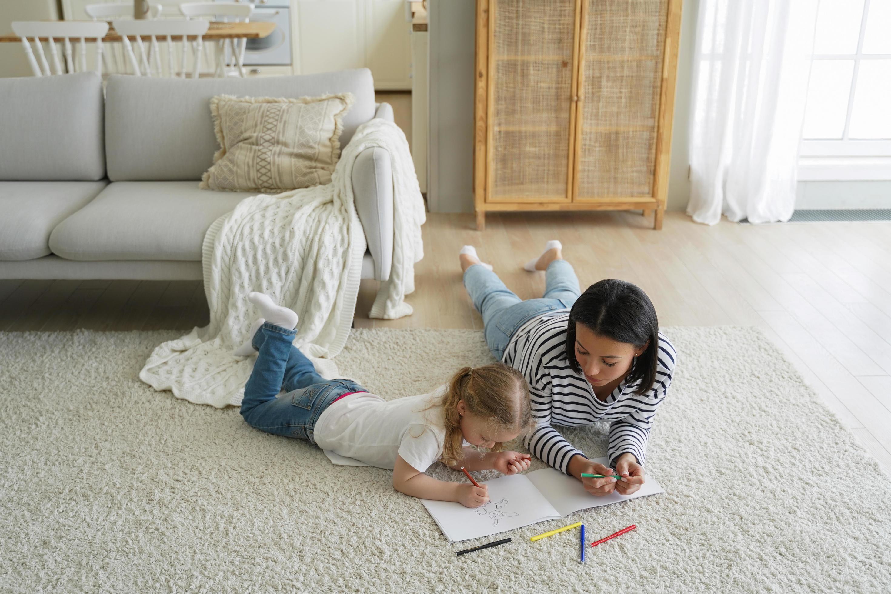 Weekend morning of family. Mum and kid lying on floor together and painting with colorful markers. Stock Free