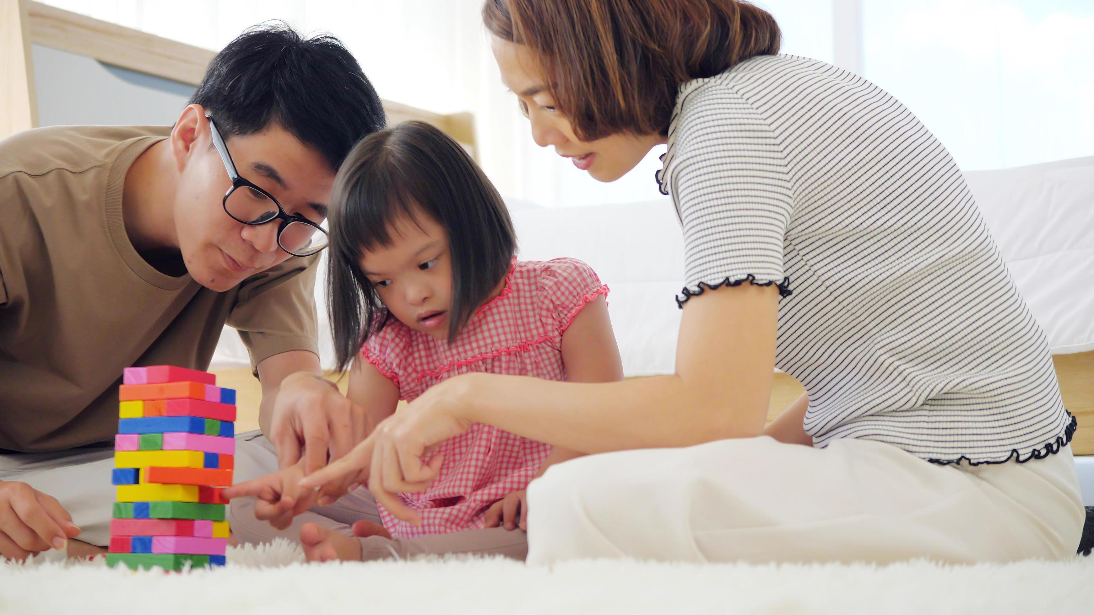 Happy family with mother, father and disabled daughter spending time together at home. Stock Free